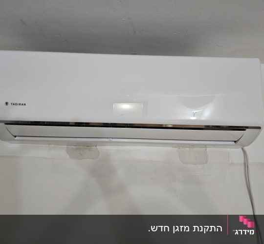 מזגן קיר לבן מותקן על קיר פנימי